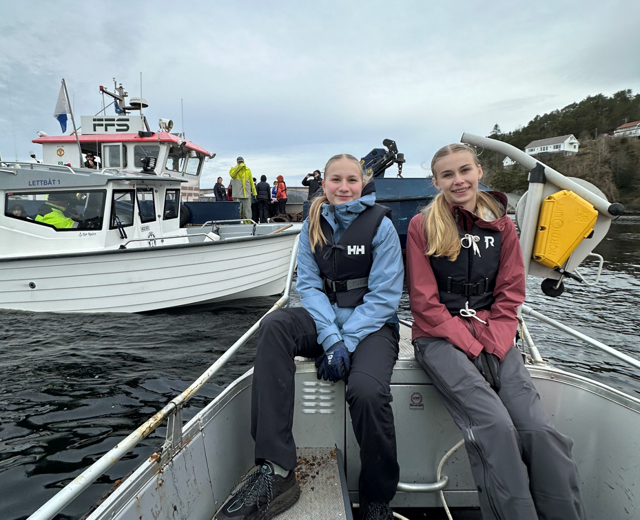To jenter fra 9.trinn er klare for å  hente opp marint avfall som dykkerne sender opp 